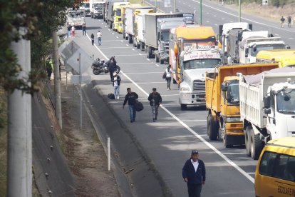 Moradores caminan a lo largo de la vía ante el cierre del tránsito vehicular, en medio de protestas que obligan a desplazarse a pie por la zona.