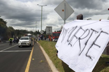 Manifestantes bloquean parcialmente una vía mientras sostienen una pancarta con la consigna “Justicia”