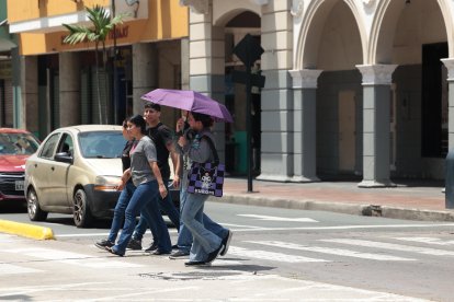Calor extremo en Guayaquil: ciudadanos se protegen de los rayos solares directos.