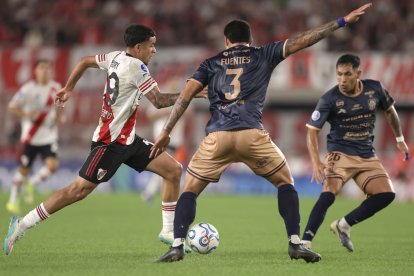 Kendry Páez (i) de River Plate disputa un balón con Jean Fuentes de Carabobo.