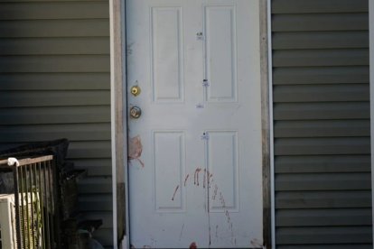 Una de las puertas afectadas durante el ataque en Luisiana mostraba manchas de sangre y señaléticas policiales de la escena del crimen.