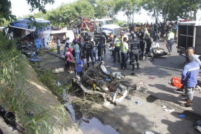 Rescatistas y personal de la CTE trabajan en el kilómetro 44 de la vía a la costa tras el fatal choque de hoy.