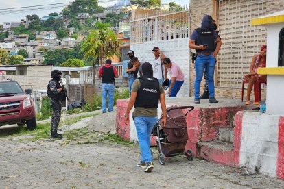 Agentes de la Policía Nacional controlan la situación en un barrio de Esmeraldas, tras la captura de dos acusados de robo en Vuelta Larga, evitando que fueran linchados por vecinos indignados.