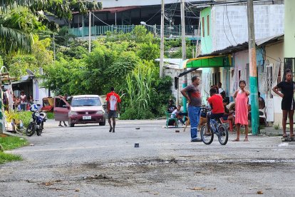 Vecinos de Isla Piedad, en la ribera del río Esmeraldas, observan la escena marcada por el asesinato de un joven reciclador cerca del colegio Ángel Barbisotti.