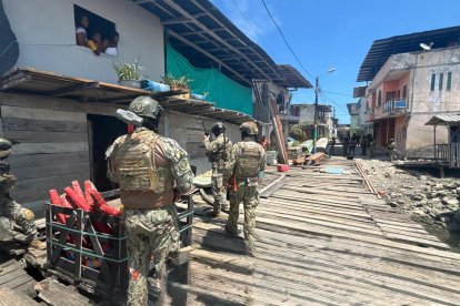 Militares armados inspeccionan viviendas sobre esteros en Limones, durante un operativo contra el narcotráfico que dejó incautaciones de químicos y embarcaciones en Esmeraldas.