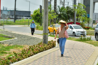Refugio. Los transeúntes buscan cubrirse del sol ante la falta de sombra.