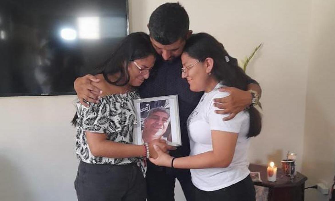 Los tres hijos de la víctima sostienen un portarretrato con la imagen de su padre. Está sonriente. Así lo recuerdan.