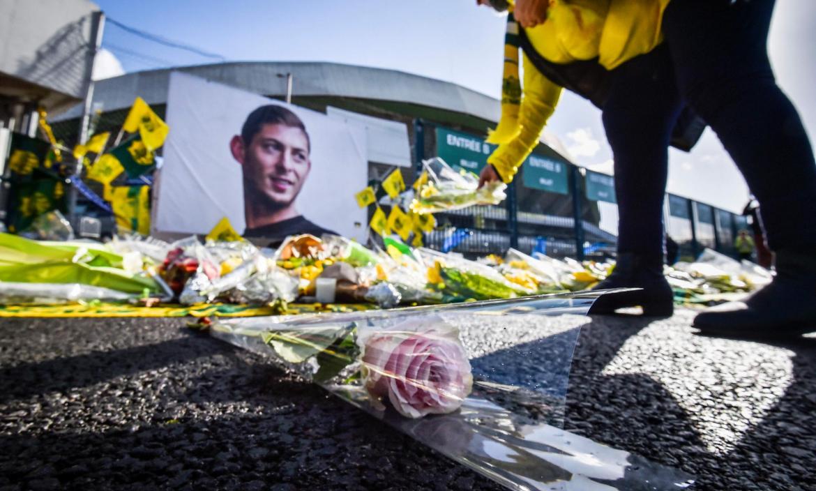 A FC Nantes supporter puts yellow flowers in front of the portrait of