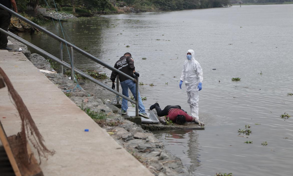 Agentes de Criminalística y de la Dinased llegaron al río Daule para retirar el cadáver.