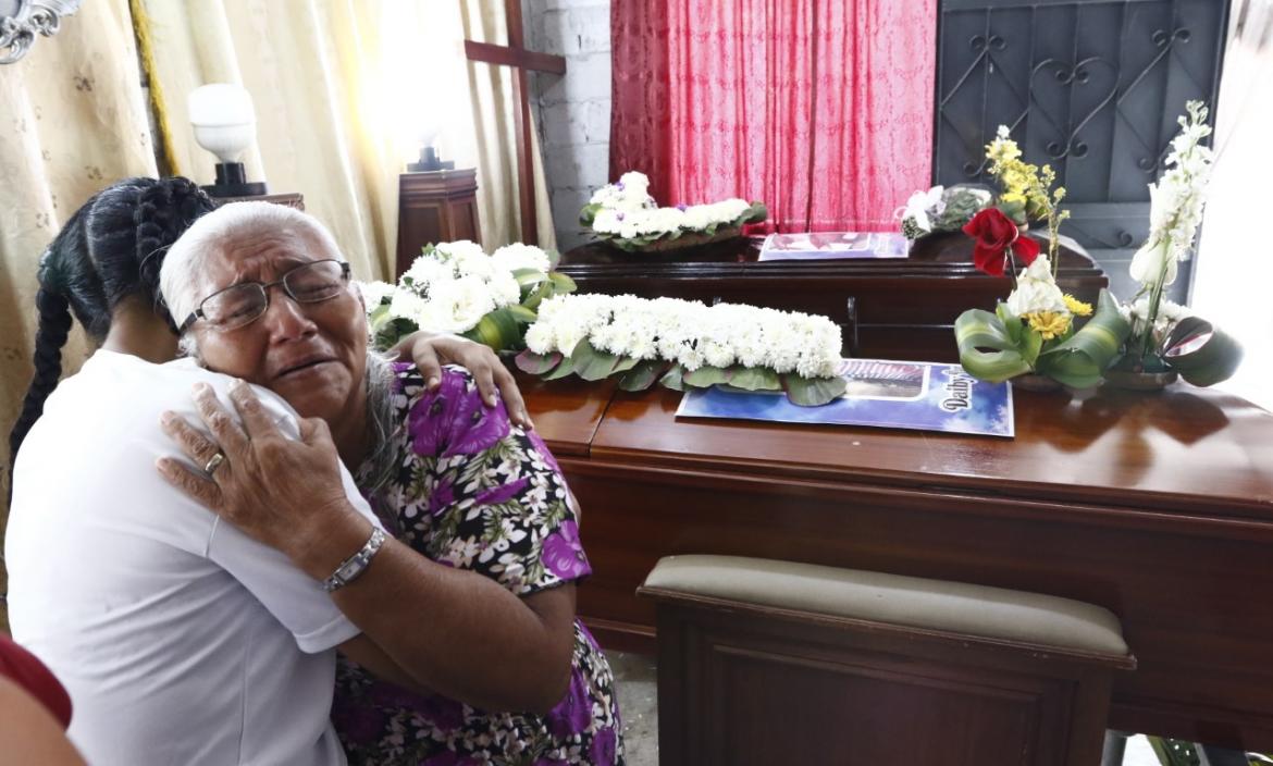 Madre llora a su hijo muerto durante su velorio.