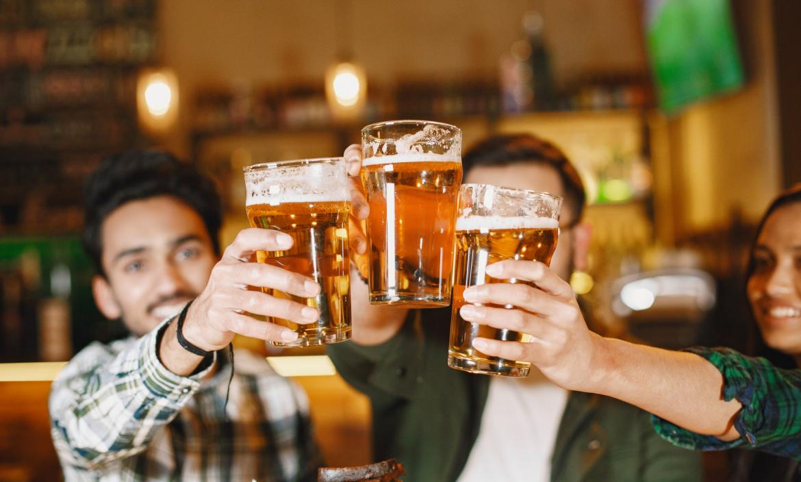 indian-friends-in-pub-guys-and-girl-at-bar-celebration-over-mug-of-beer