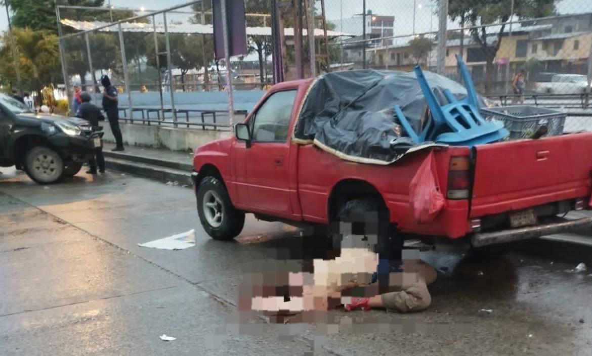 El cuerpo de Carlos Augusto Ramírez Vera quedó doblado de espalda, junto a una camioneta roja.