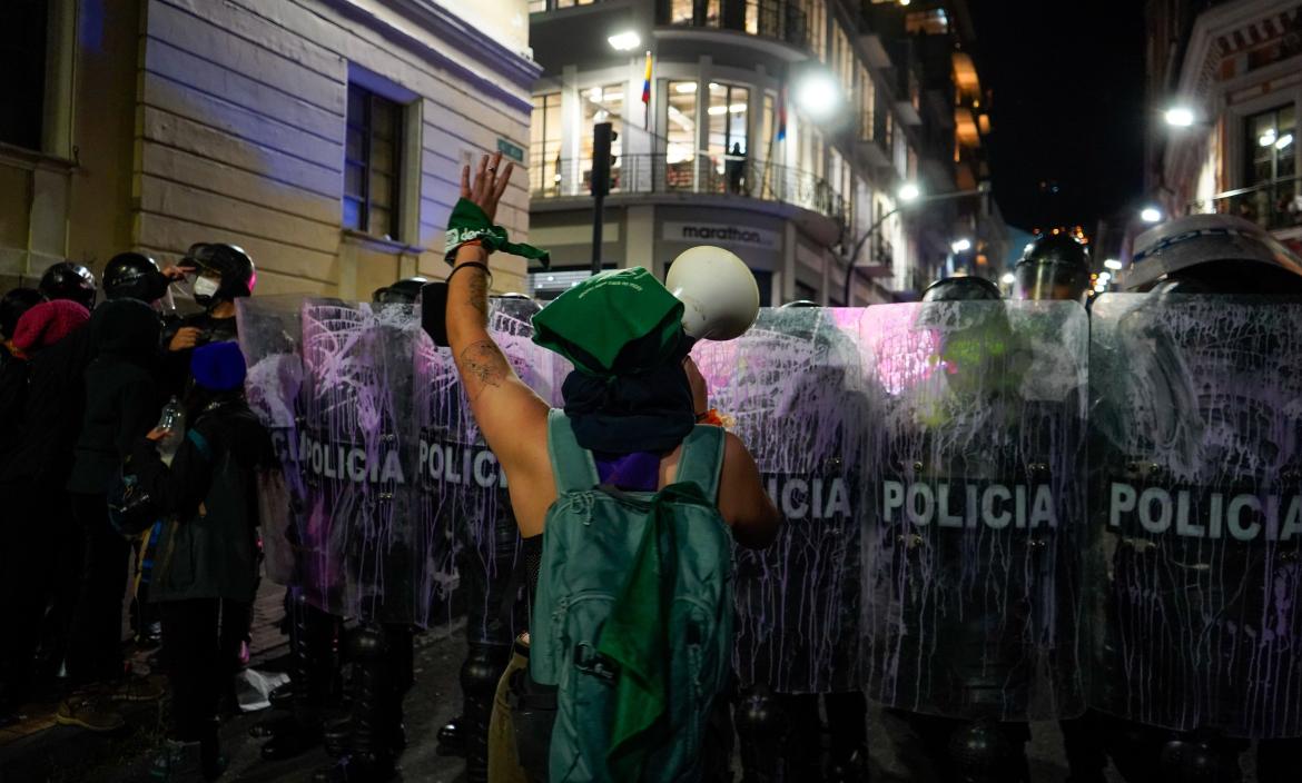 Mujer frente a los policías en marcha por el 8M en Quito.