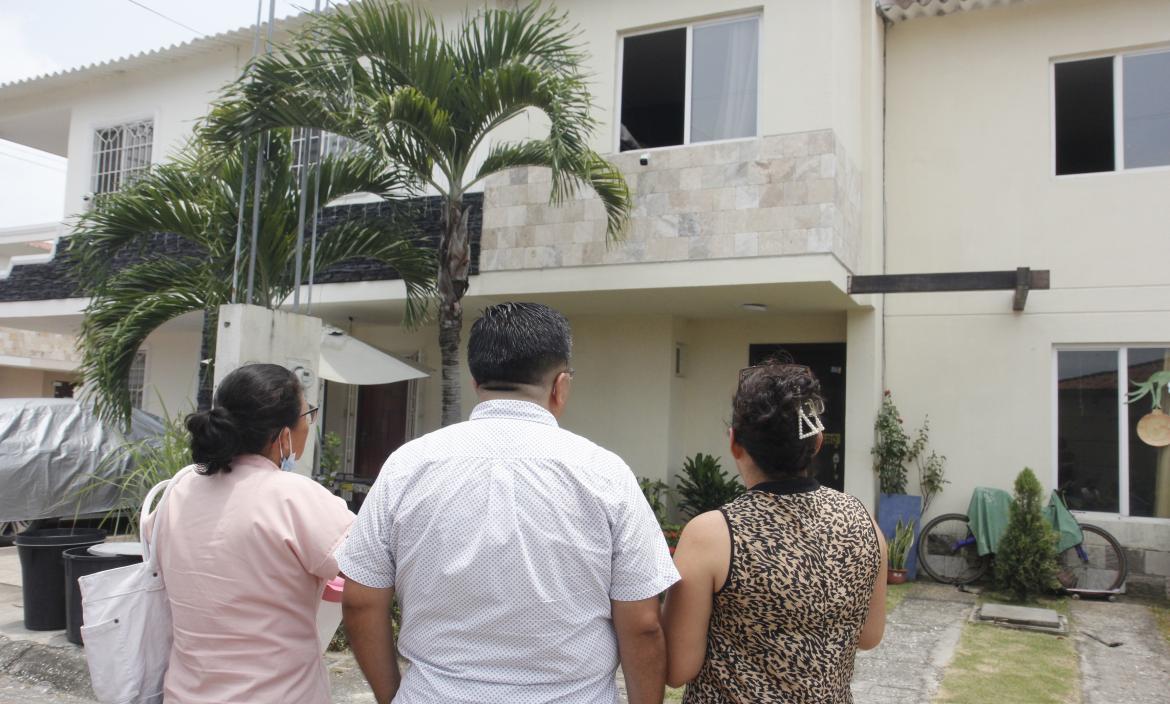 Vecinos observan, consternados, la casa donde el lunes 20 de marzo tres miembros de una familia murieron intoxicados.