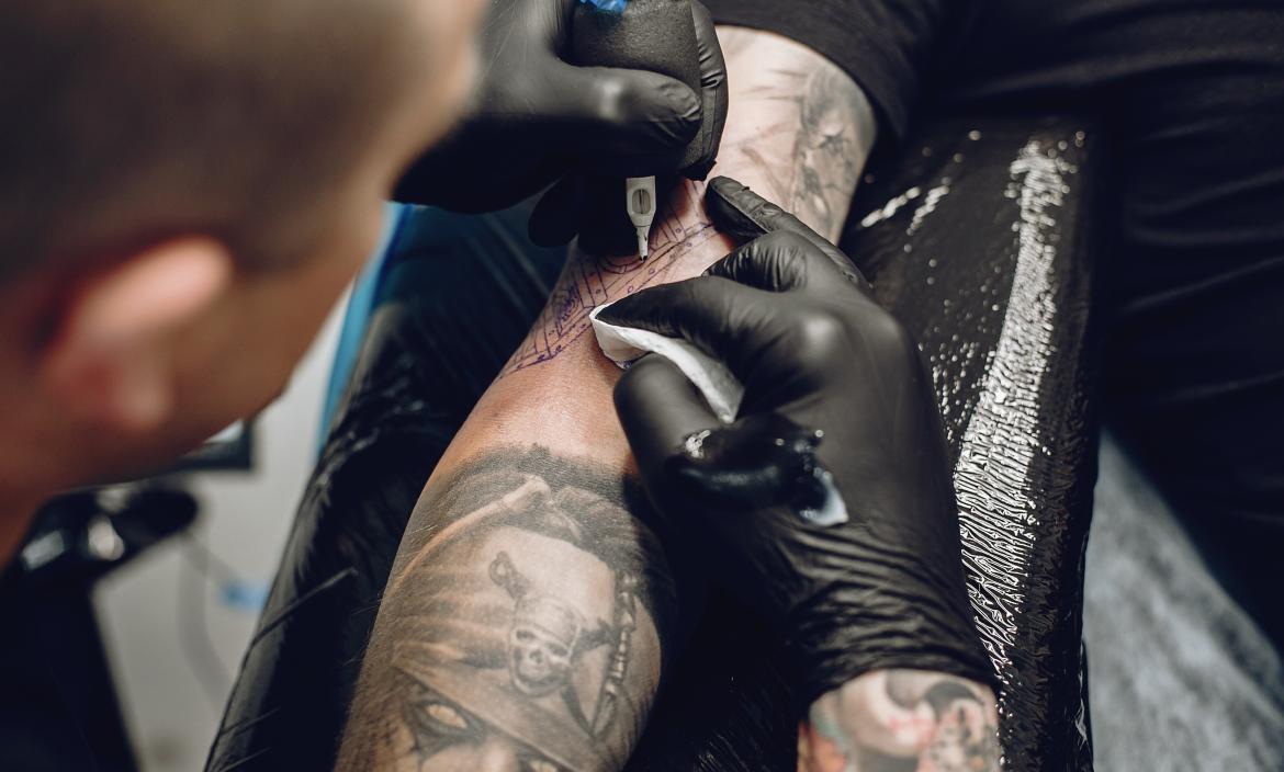 hombre-haciendo-tatuaje-salon-tatuajes