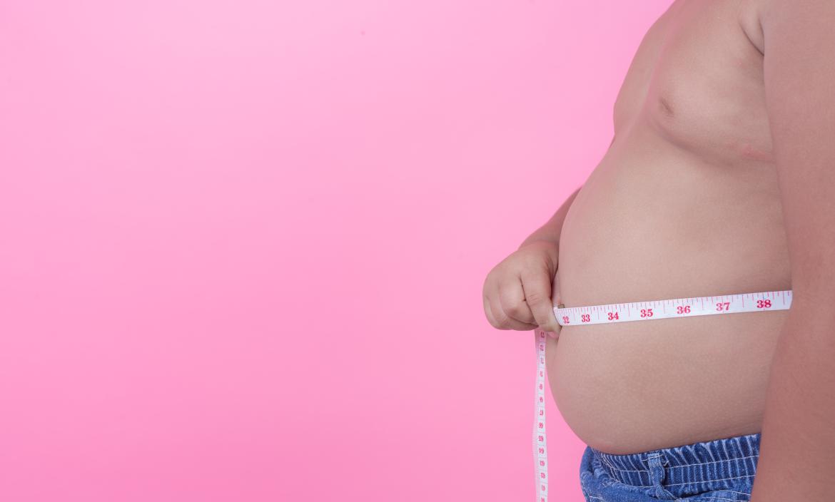 nino-obeso-que-tiene-sobrepeso-sobre-fondo-rosa