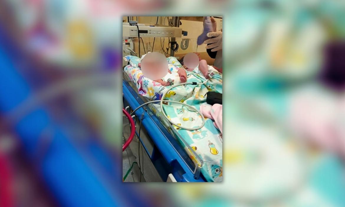 En esta imagen proporcionada por el Cuerpo de Bomberos de Quito se observa a la madre y sus gemelos en la cama de un hospital.