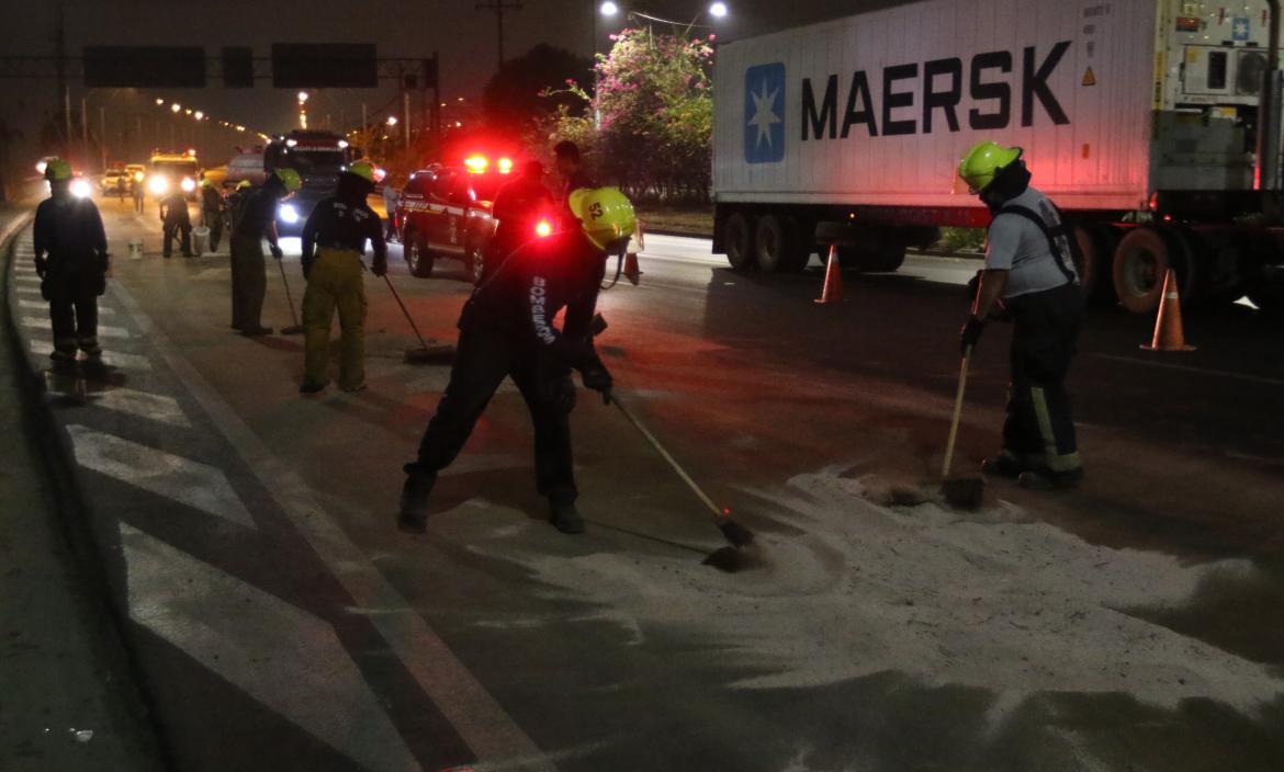 En el Puente de la Unidad Nacional, el Cuerpo de Bomberos hace limpieza de aceite derramado en la vía.