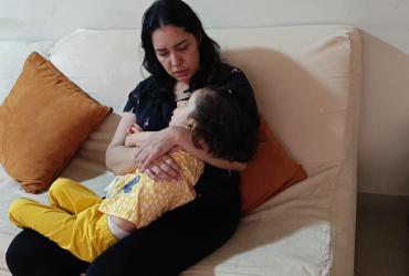 Mónica Gómez mientras trata de arrullar a su pequeña Fátima.