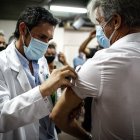 Un hombre es vacunado hoy contra la covid-19 en el Hospital Fiorito, en Avellaneda.