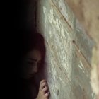 Sobre un muro de bloque y cemento, la menor de edad hablaba con sus vecinas.