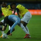 Agustín Álvarez de Uruguay disputa el balón con Pervis Estupiñán (i) y Piero Hincapie (d) de Ecuador.
