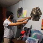 Xavier muestra los cuadros que ha pintado y que pretende vender en 30 dólares.