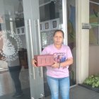 Dayanna Herrera sostiene el cofre donde la reposan las cenizas de Victoria.