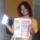 Katherine felizota muestra el diario que la convirtió en ganadora de una orden de compras.