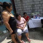 María (de pie), acompañada de sus tres hijas quienes son personas con discapacidad, observa la fotografía de su amado Joaquín.