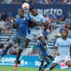 El delantero Jaime Ayoví (i), de Emelec, va a la disputa del balón contra el defensa Carlos Medina, de la Católica.