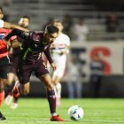 Sabino (i) de Sao Paulo disputa el balón con Lisandro Alzugaray de LDU, en un partido de cuartos de final de la Copa Libertadores.