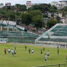 Jugadores de Esmeraldas Petrolero disputan el amistoso conmemorativo en el estadio Jorge Anderson, rodeados del fervor barrial y la memoria de un ascenso histórico.