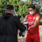 Matías Oyola se desinfecta las manos antes de entrar a la cancha.