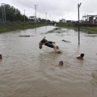 Niños saltando en el drenaje de la calle cerca de Sittwe, estado de Rakhine, oeste de Myanmar.