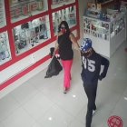 La mujer lleva la funda negra donde guardó los aparatos electrónicos. A su lado otro de los implicados.