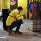 Agentes de Criminalística analizan los indicios encontrados en el sitio del ataque.