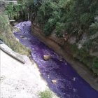 El caudal del río se tiñó de morado el lunes. Las autoridades investigan el origen de esta contaminación.