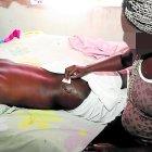  La esposa del afectado limpia con un algodón la herida que tiene en el glúteo. 