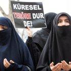  Personas cantan consignas y sostienen pancartas durante una manifestación en protesta por el atentado ocurrido este viernes. 