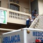  Agentes de la Policía retiran el cuerpo de la víctima envuelto en una sábana. 