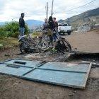  Las motos incineradas de los supuestos pillos; atrás, los vecinos.  