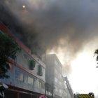  Momento en el que se presentaba este sábado el incendio en ese lugar tan concurrido del Puerto Principal. Se ve cómo los bomberos luchan contra las llamas. 