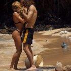  Pareja protagonista en medio la playa llena de desechos  