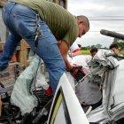  Personal de rescate ayuda a liberar el cuerpo de la víctima, atrapado en la cabina de su vehículo. 