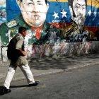  Un hombre camina por los graffiti del héroe revolucionario sudamericano Simón Bolívar, el fallecido presidente de Venezuela, Hugo Chávez, y el presidente de Venezuela, Nicolás Maduro, en Caracas. 