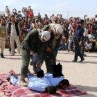  Los oficiales colocan sus AK-47 sobre las espaldas de los ajusticiados, para cumplir con su sentencia. 