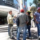  En los exteriores del Ministerio de Trabajo, un grupo de personas dialoga sobre el salario. 