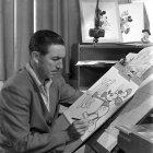  El productor, director, guionista y animador estadounidense Walter Elias Disney, conocido por Walt Disney, mientras dibuja a su personaje más famoso, Mickey Mouse.  