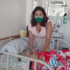 Jéssica está junto a la cama de hospital en la que duerme su bebé de tres meses.